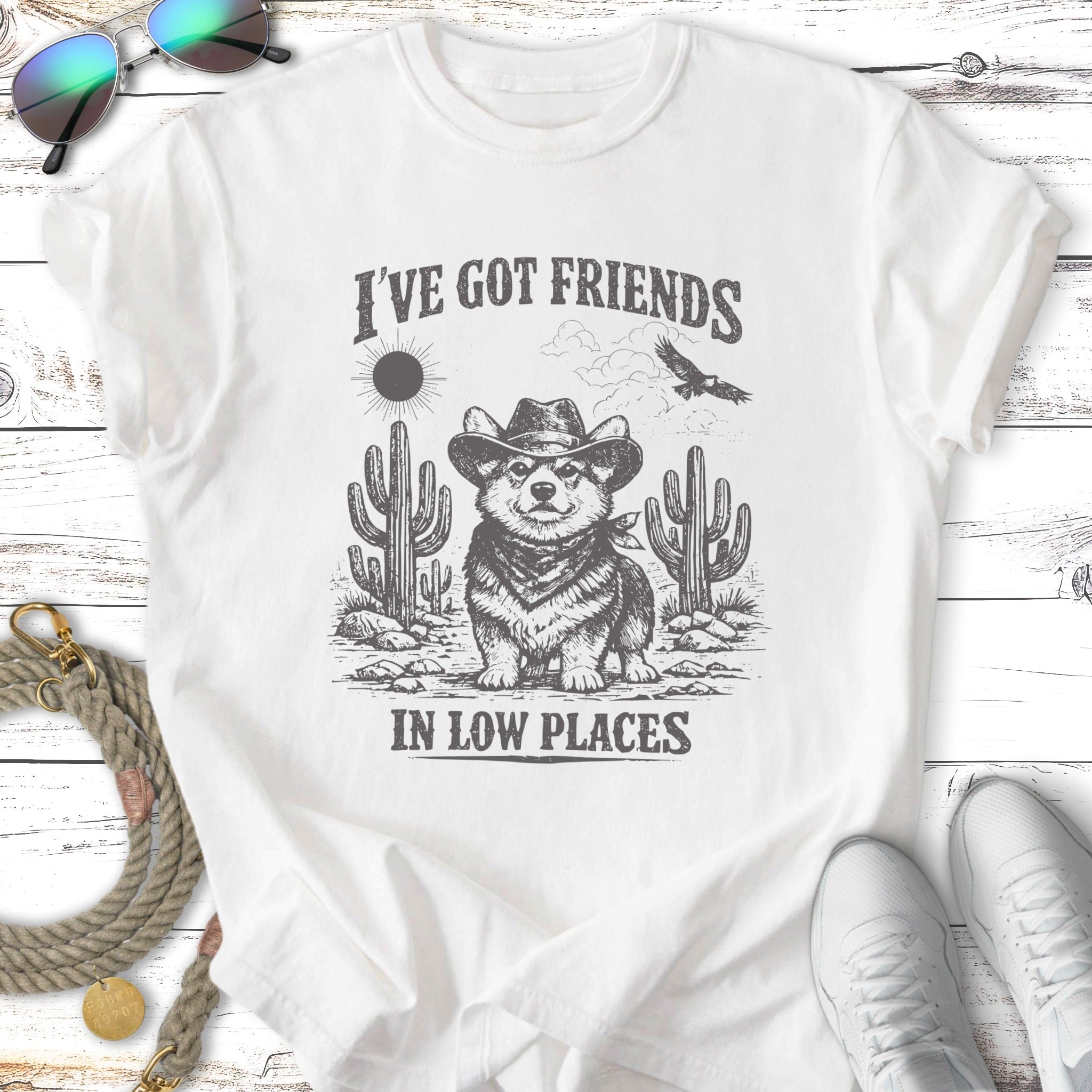 Corgi in cowboy hat with cactus and eagle, text "I've got friends in low places".