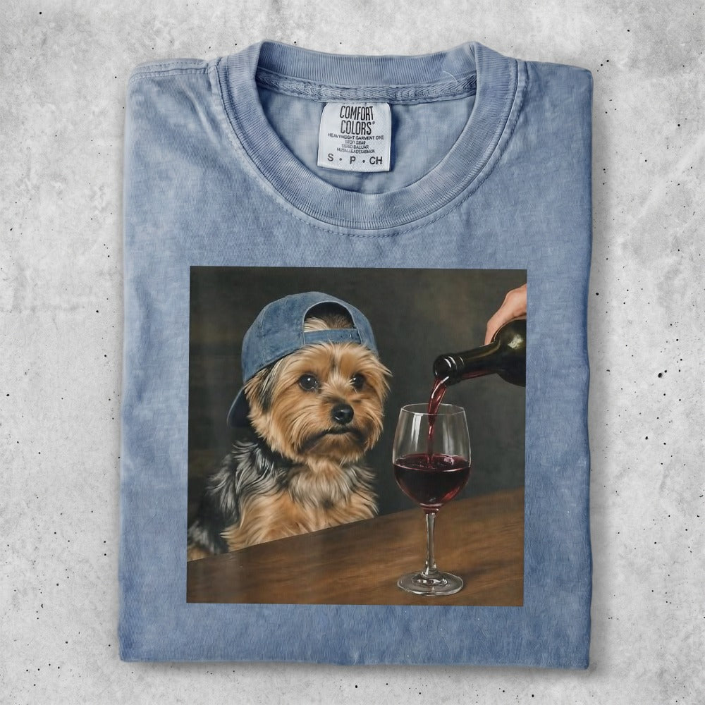 T-shirt featuring a painting of a dog wearing a baseball cap pouring red wine.