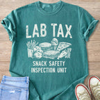 Teal t-shirt with "LAB TAX SNACK SAFETY INSPECTION UNIT" and drawings of snacks.