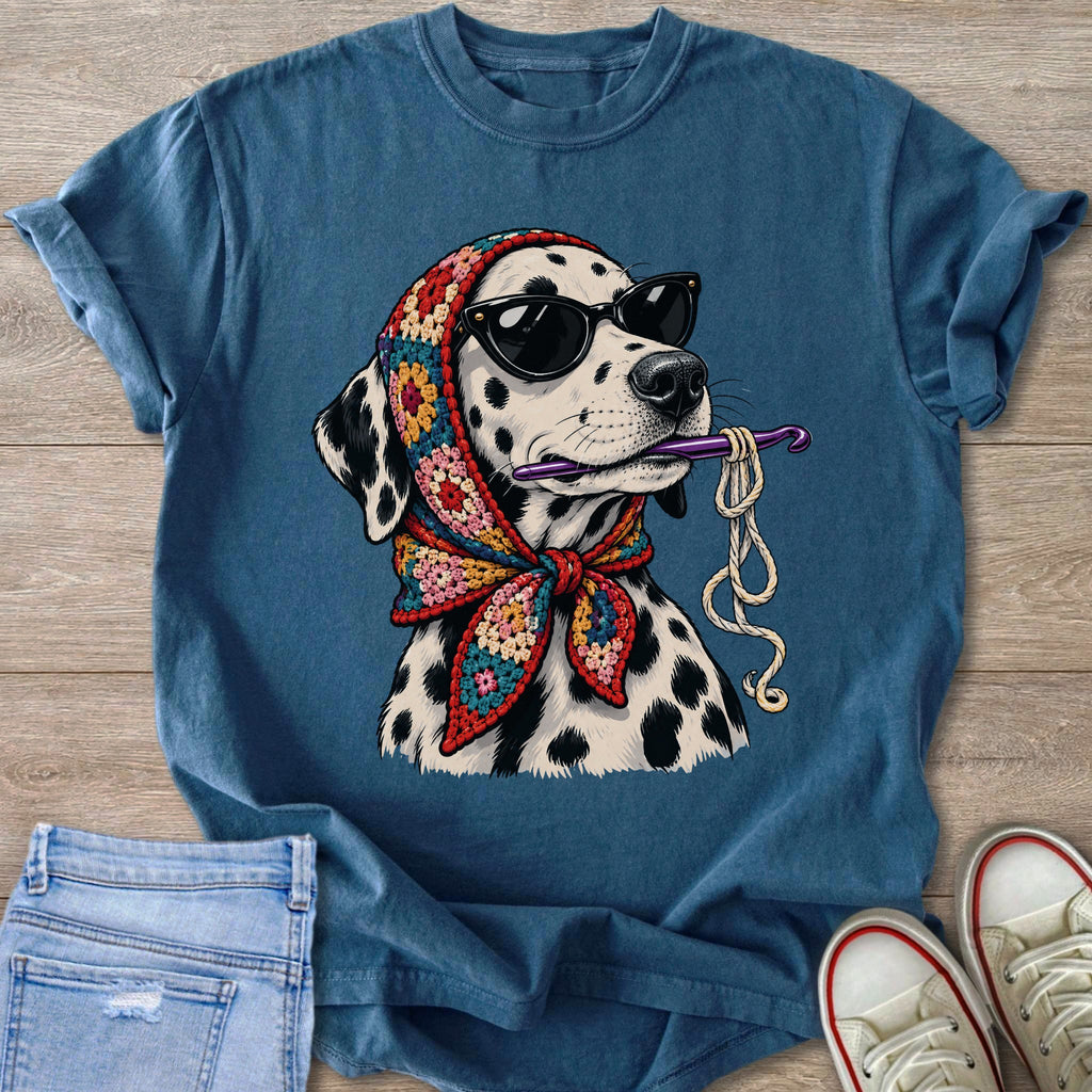 Dalmatian wearing sunglasses and a colorful scarf, holding a crochet hook and yarn.