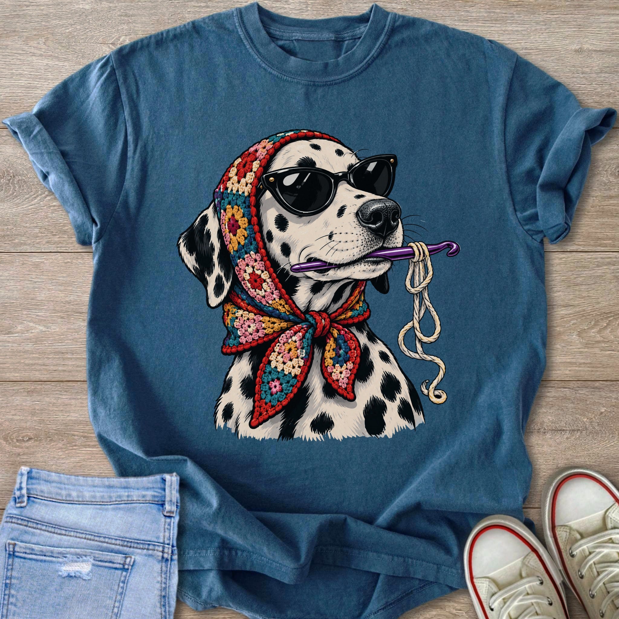 Dalmatian wearing sunglasses and a colorful scarf, holding a crochet hook and yarn.