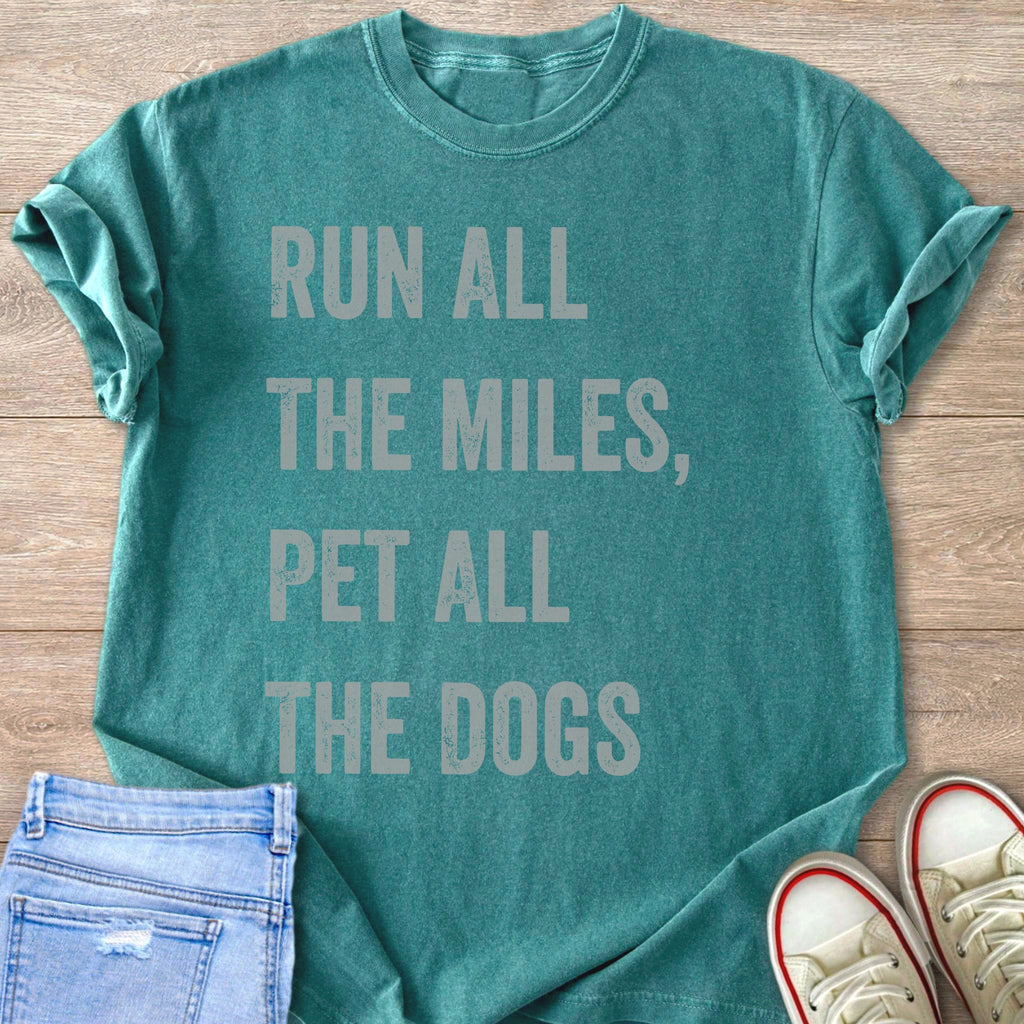 Teal t-shirt with text "RUN ALL THE MILES, PET ALL THE DOGS".