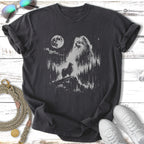 Pomeranian dog silhouetted against moonlit forest scene on dark t-shirt.