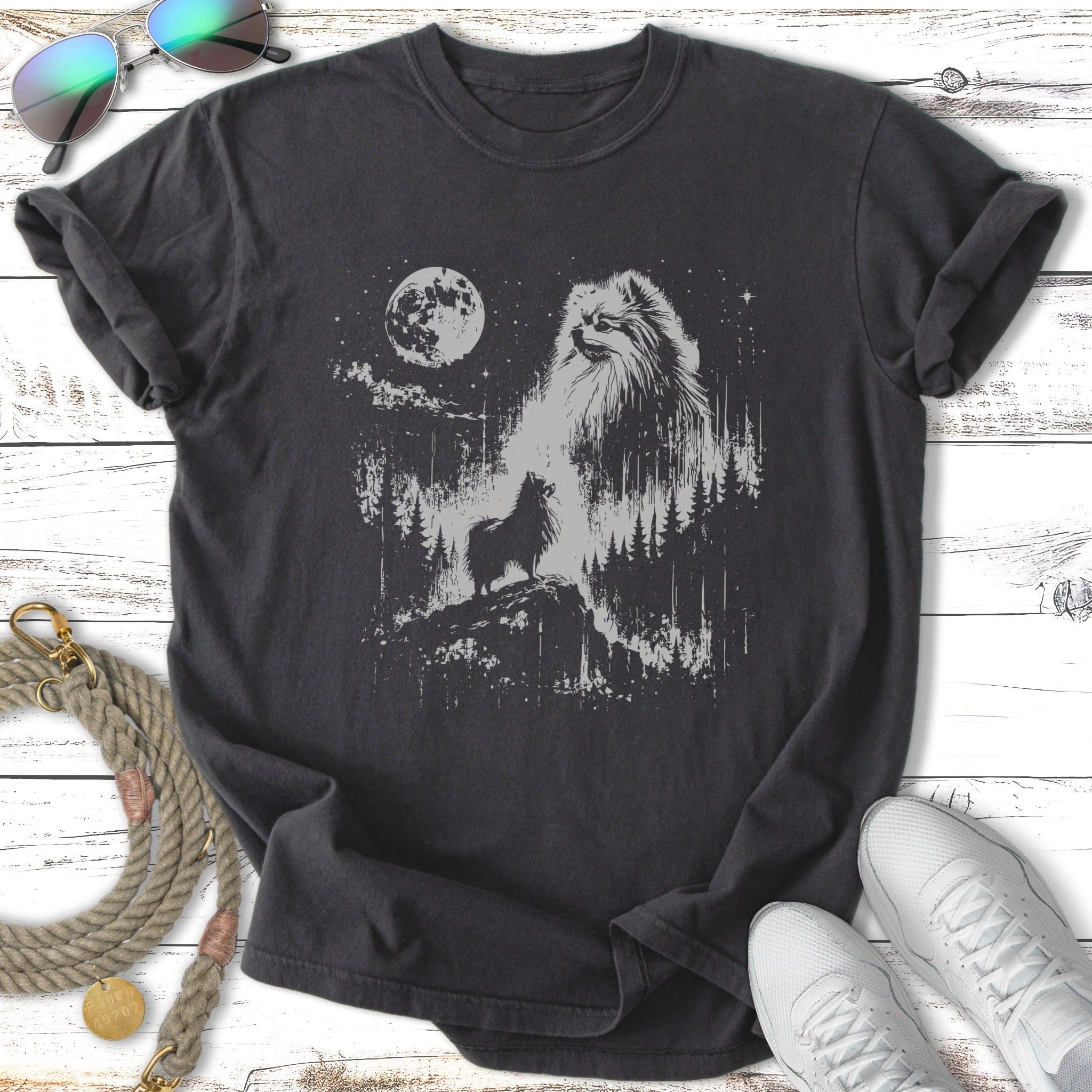 Pomeranian dog silhouetted against moonlit forest scene on dark t-shirt.