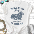 T-shirt with dachshund illustration and text "Real Men Play With Their Weiners".