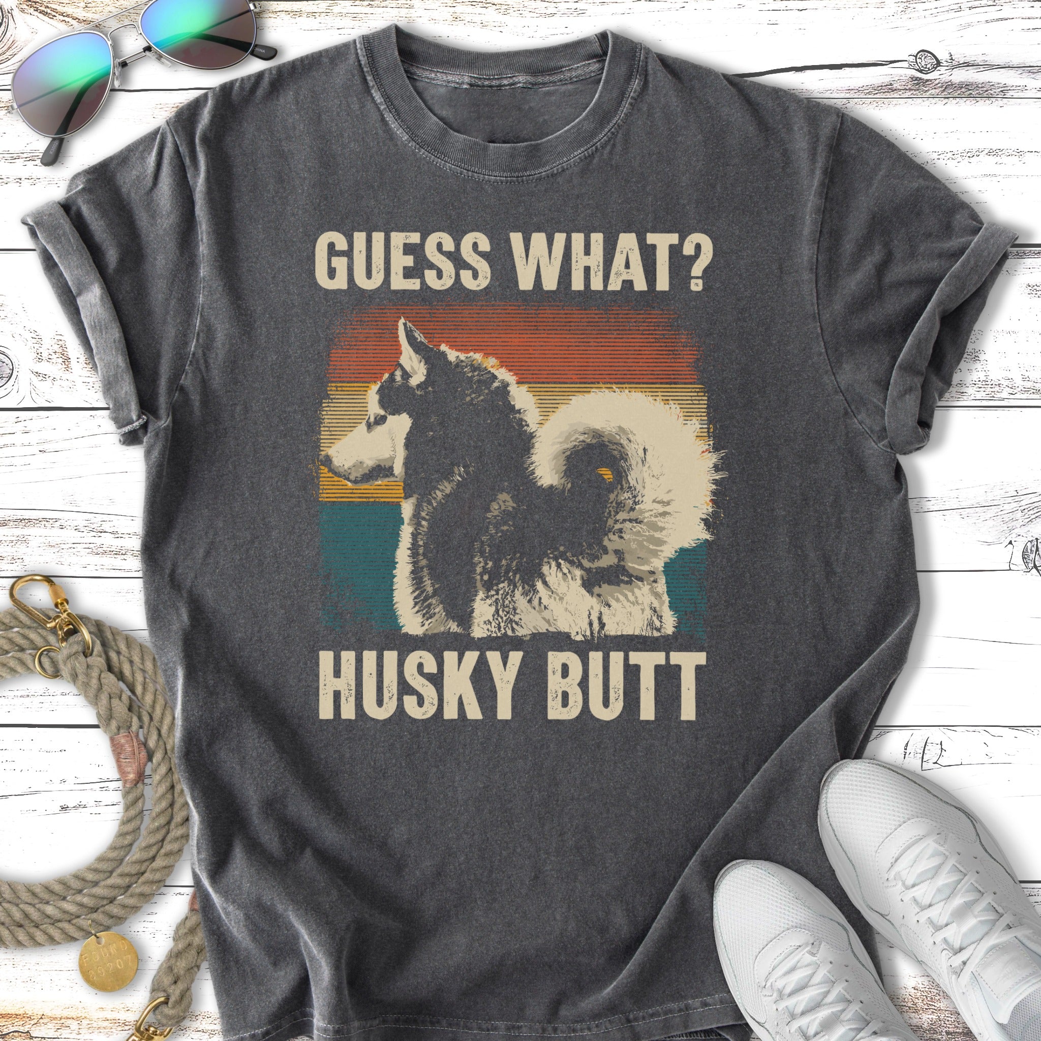 Graphic t-shirt with vintage sunset and husky dog, text reads "GUESS WHAT? HUSKY BUTT".