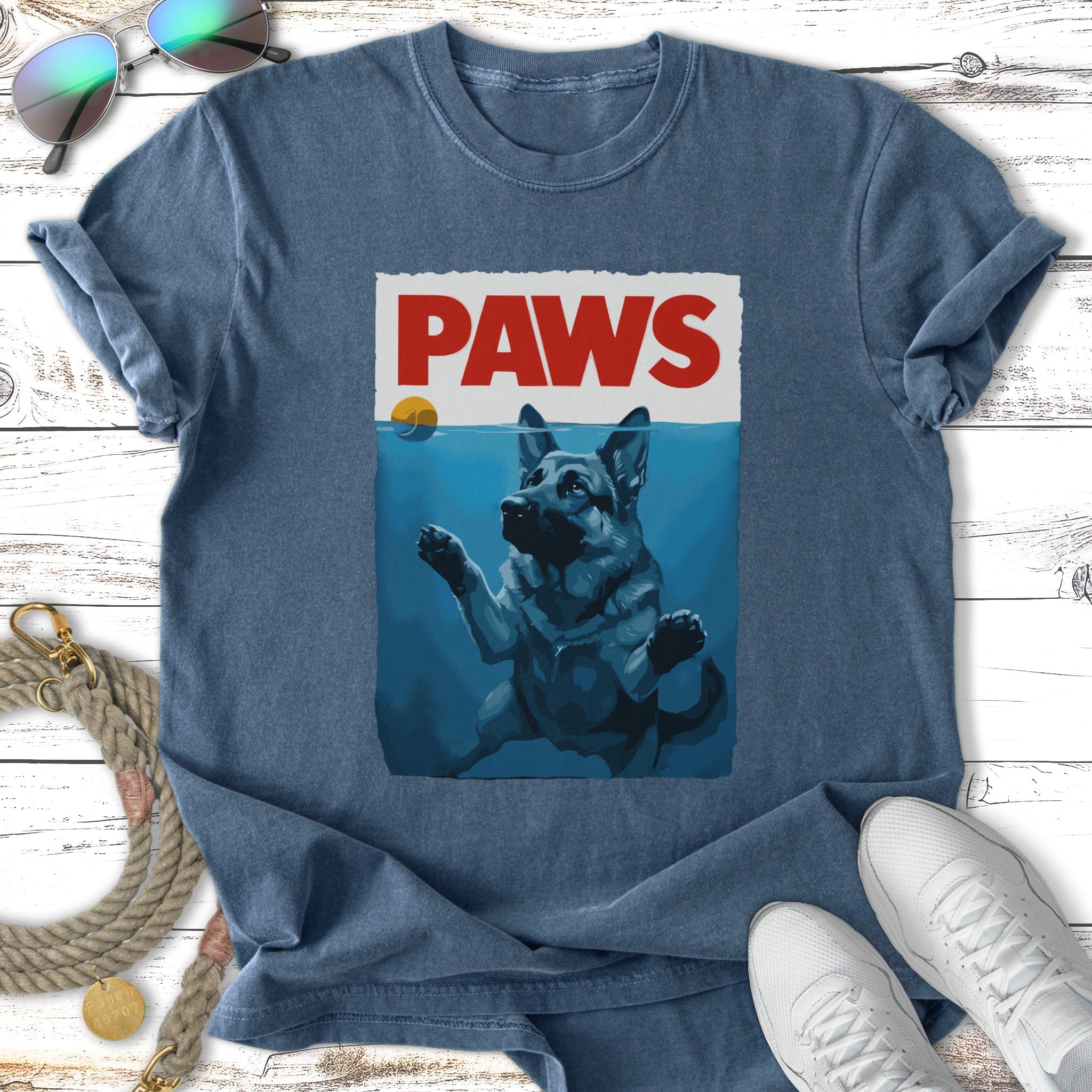 German Shepherd dog swimming underwater with "PAWS" text above.