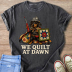 Dachshund wearing a helmet holding a seam ripper and quilt, text reads "WE QUILT AT DAWN".