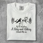 White t-shirt with "If It Involves A Dog and Hiking Count Me In" graphic.