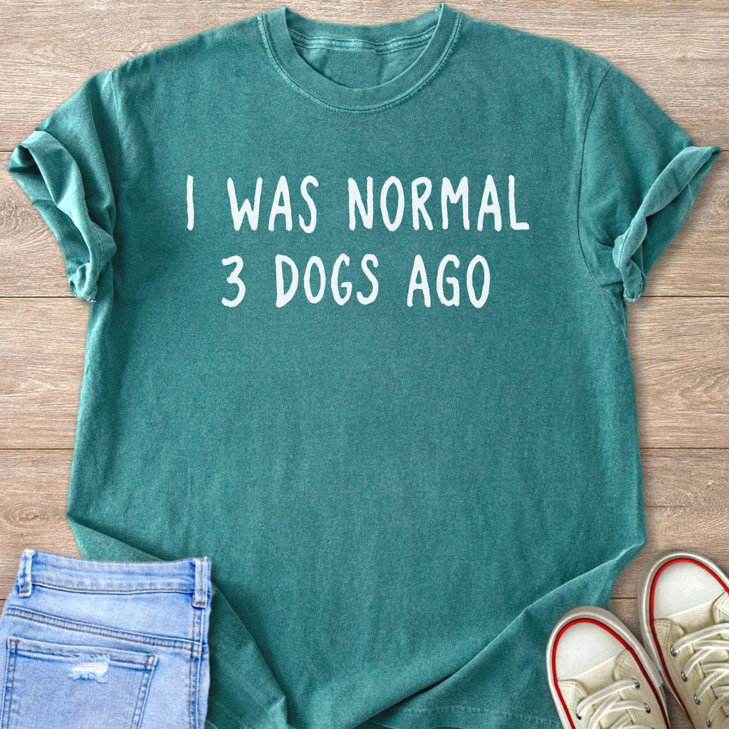 Teal t-shirt with "I WAS NORMAL 3 DOGS AGO" text printed in white.