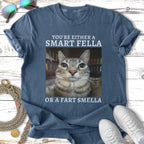 Cat wearing a t-shirt that reads "You're Either A Smart Fella Or A Fart Smella".