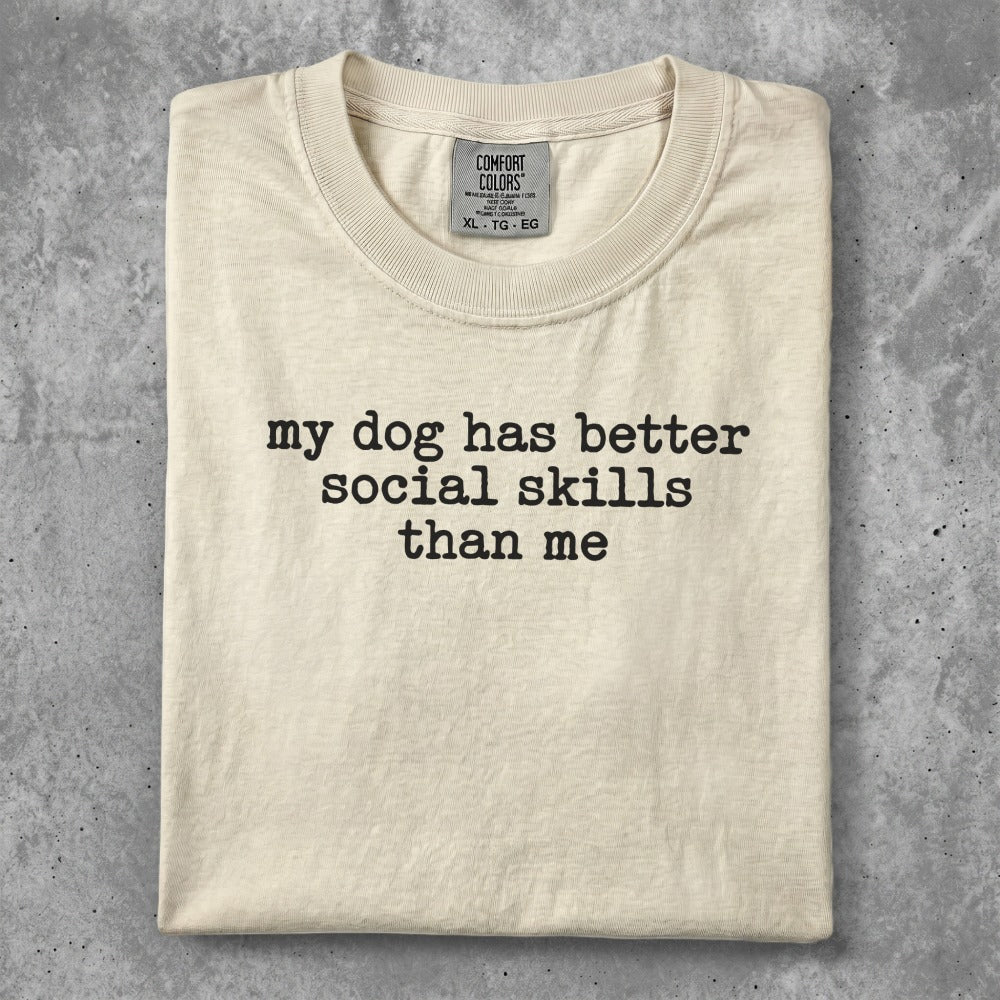 Cream t-shirt with "My dog has better social skills than me" text.