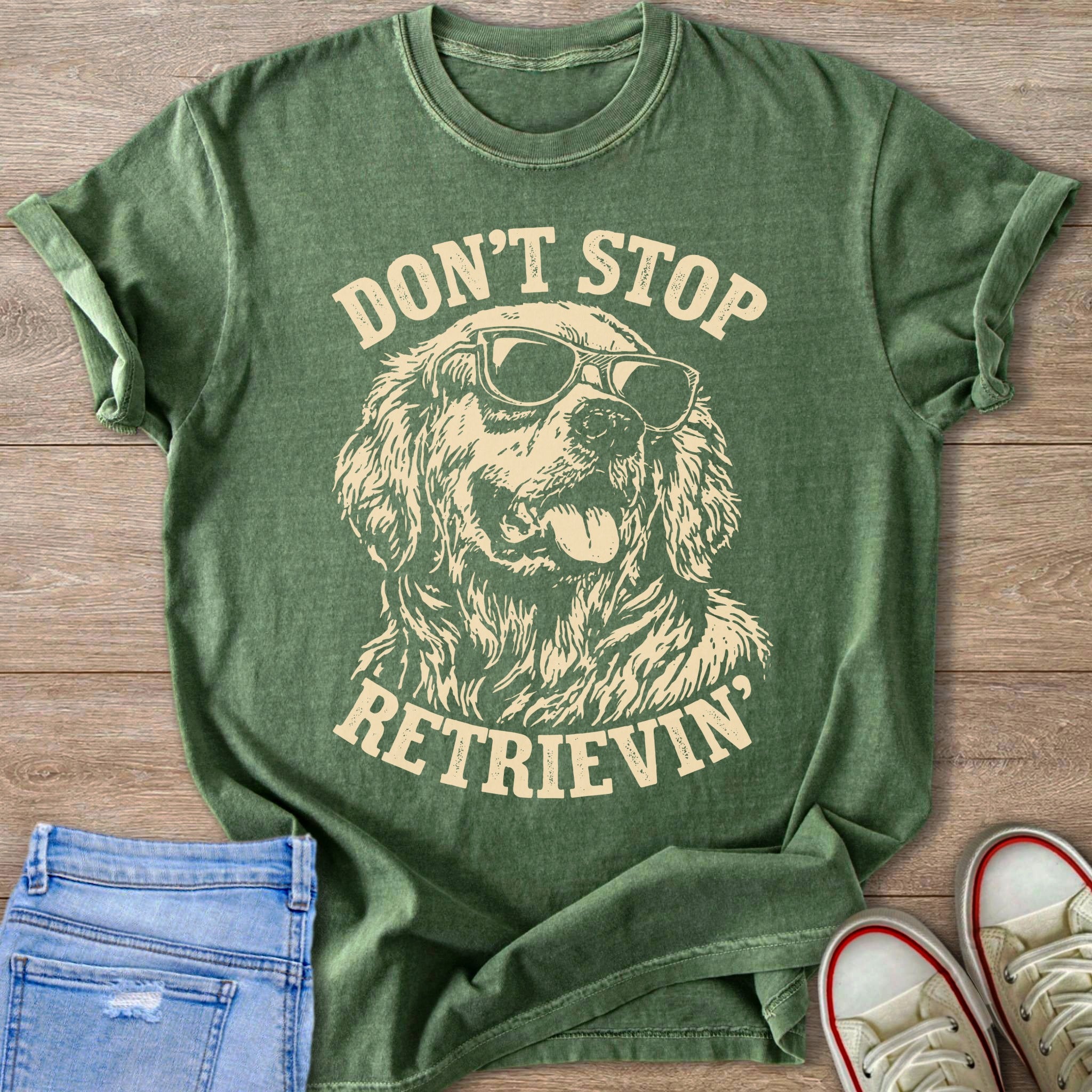 Green t-shirt with distressed graphic of a golden retriever wearing sunglasses and text "DON'T STOP. RETRIEVIN'."