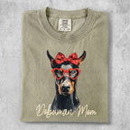 Doberman Mom t-shirt with dog wearing heart glasses and red bow.