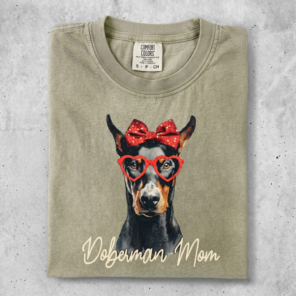 Doberman Mom t-shirt with dog wearing heart glasses and red bow.