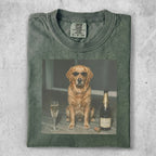 Golden retriever in sunglasses sits next to champagne and a glass.