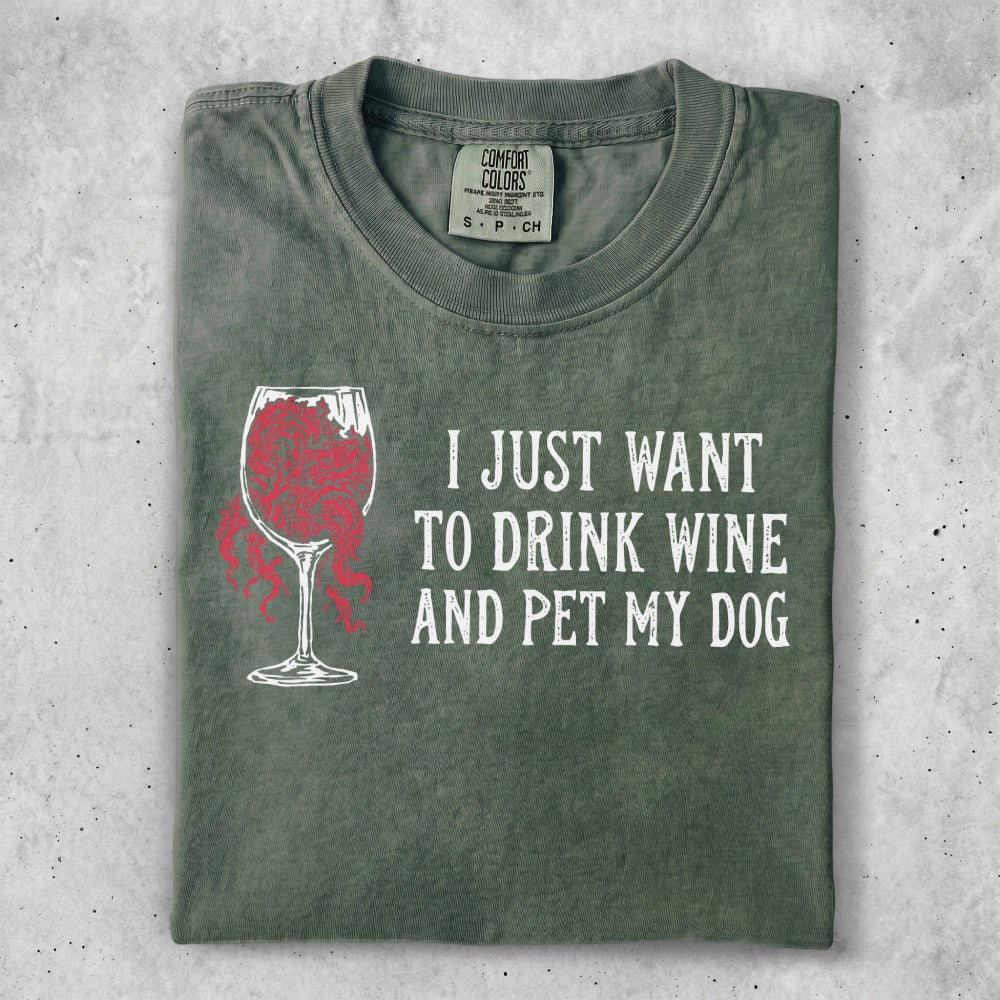 Green t-shirt with red wine glass graphic and text "I JUST WANT TO DRINK WINE AND PET MY DOG."