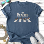 Four beagles walk across a crosswalk on a blue t-shirt design.