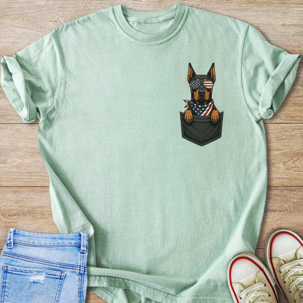 Doberman dog in pocket wearing American flag sunglasses and bandana.