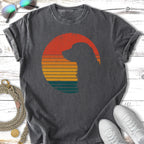 Dog silhouette within a striped sunset circle on a charcoal t-shirt.