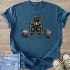 French bulldog with muscular build lifting a barbell on a blue t-shirt.