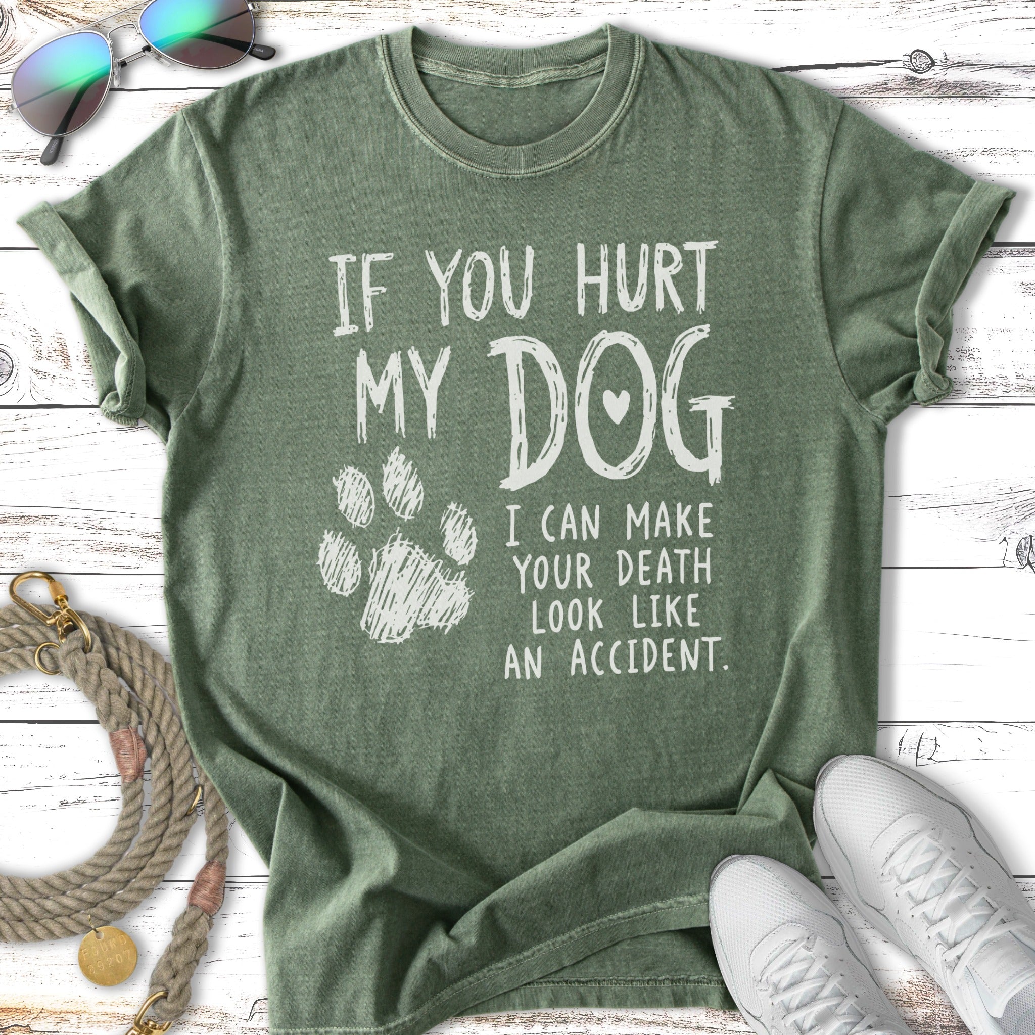 Green t-shirt with white text "If you hurt my dog, I can make your death look like an accident."