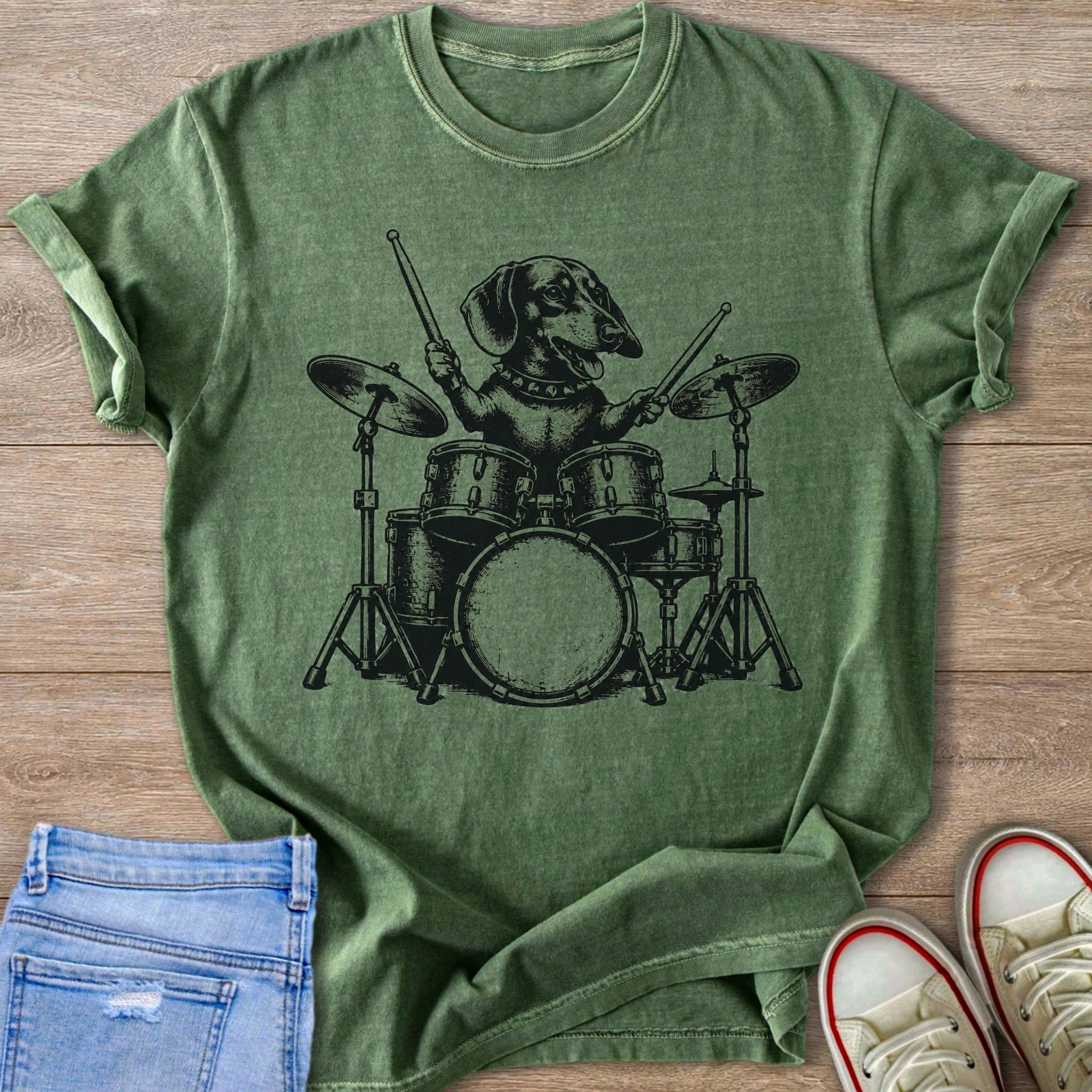 Dachshund playing a drum set on a green t-shirt.