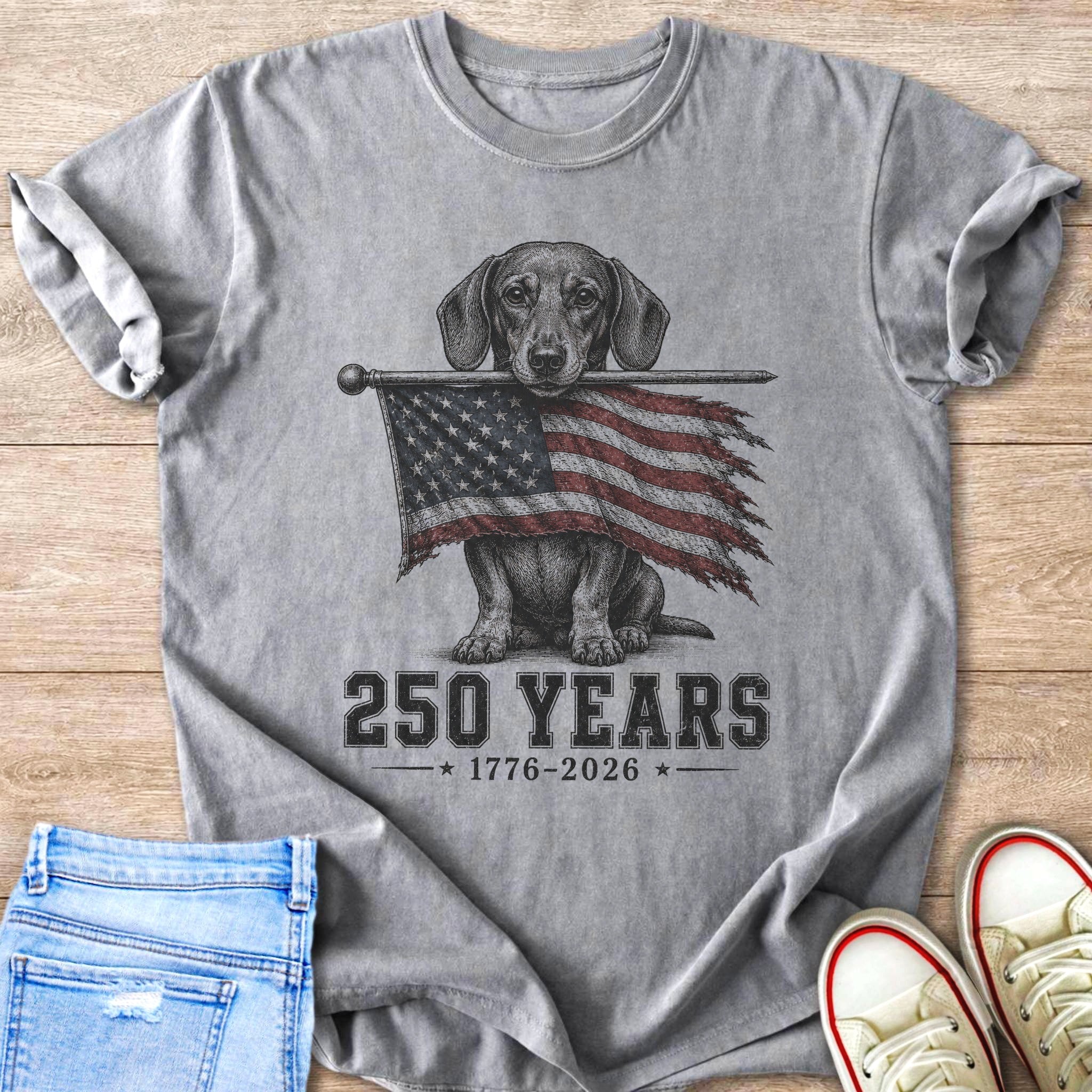 Dachshund holding tattered American flag with "250 YEARS 1776-2026" text.