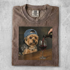 Yorkshire terrier wearing a baseball cap, being poured red wine into a glass.