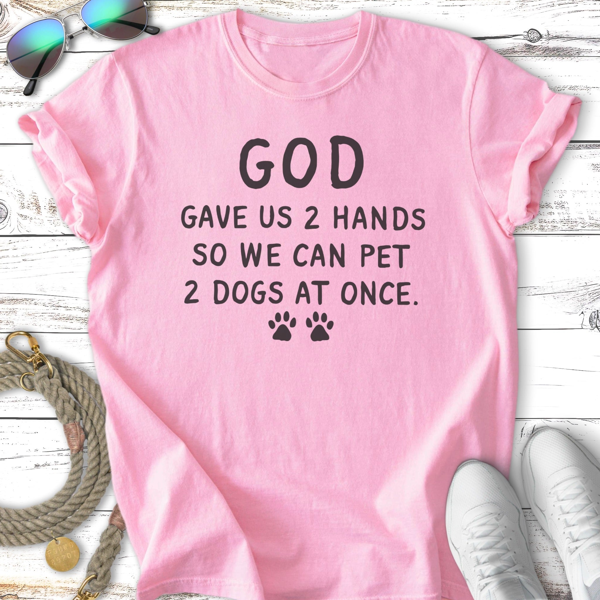 Pink t-shirt with "God gave us 2 hands so we can pet 2 dogs at once" text.