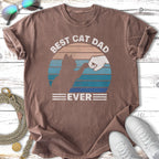 Brown t-shirt with "Best Cat Dad Ever" text and cat fist bump graphic.