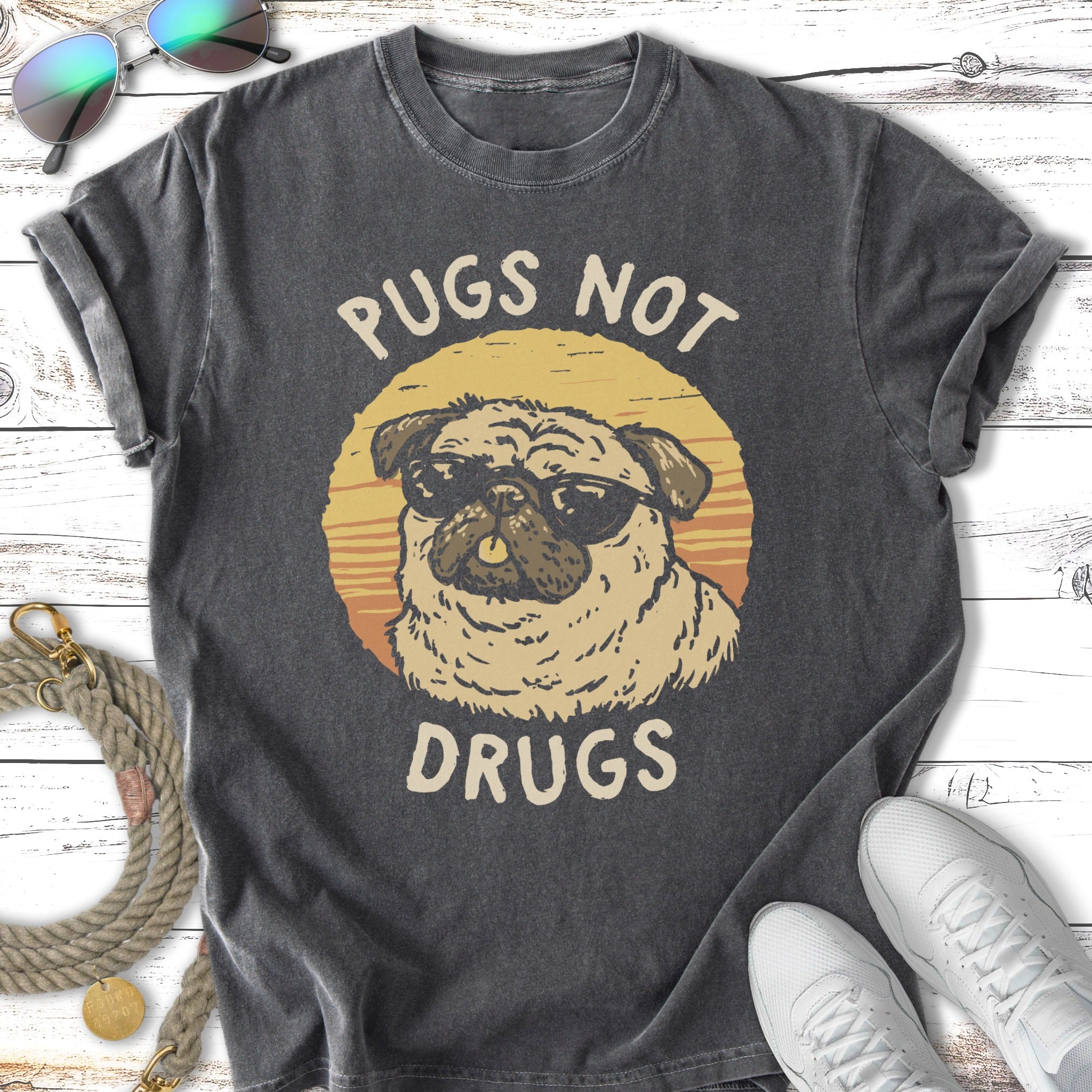 Pug wearing sunglasses with "Pugs Not Drugs" text.