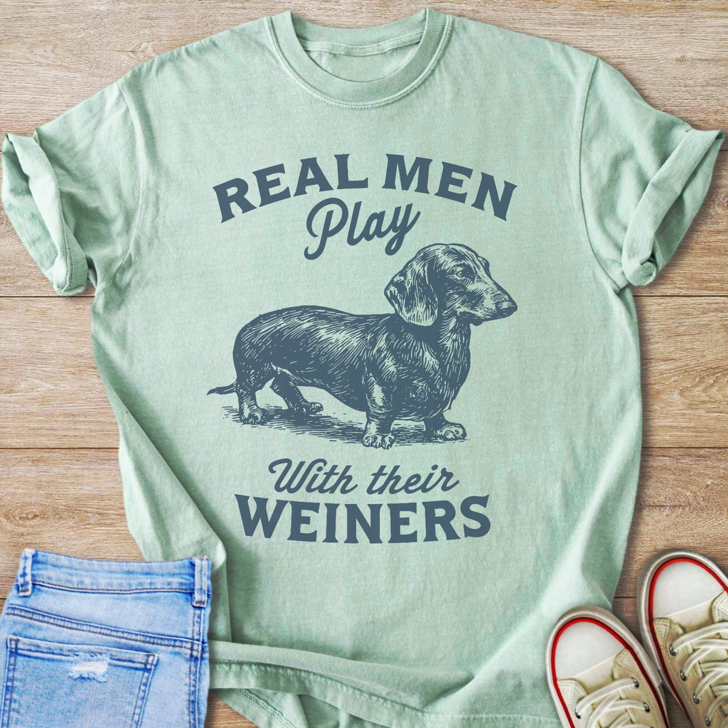 Light green t-shirt with dachshund graphic and text "Real Men Play With Their Weiners".