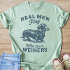Light green t-shirt with dachshund graphic and text "Real Men Play With Their Weiners".