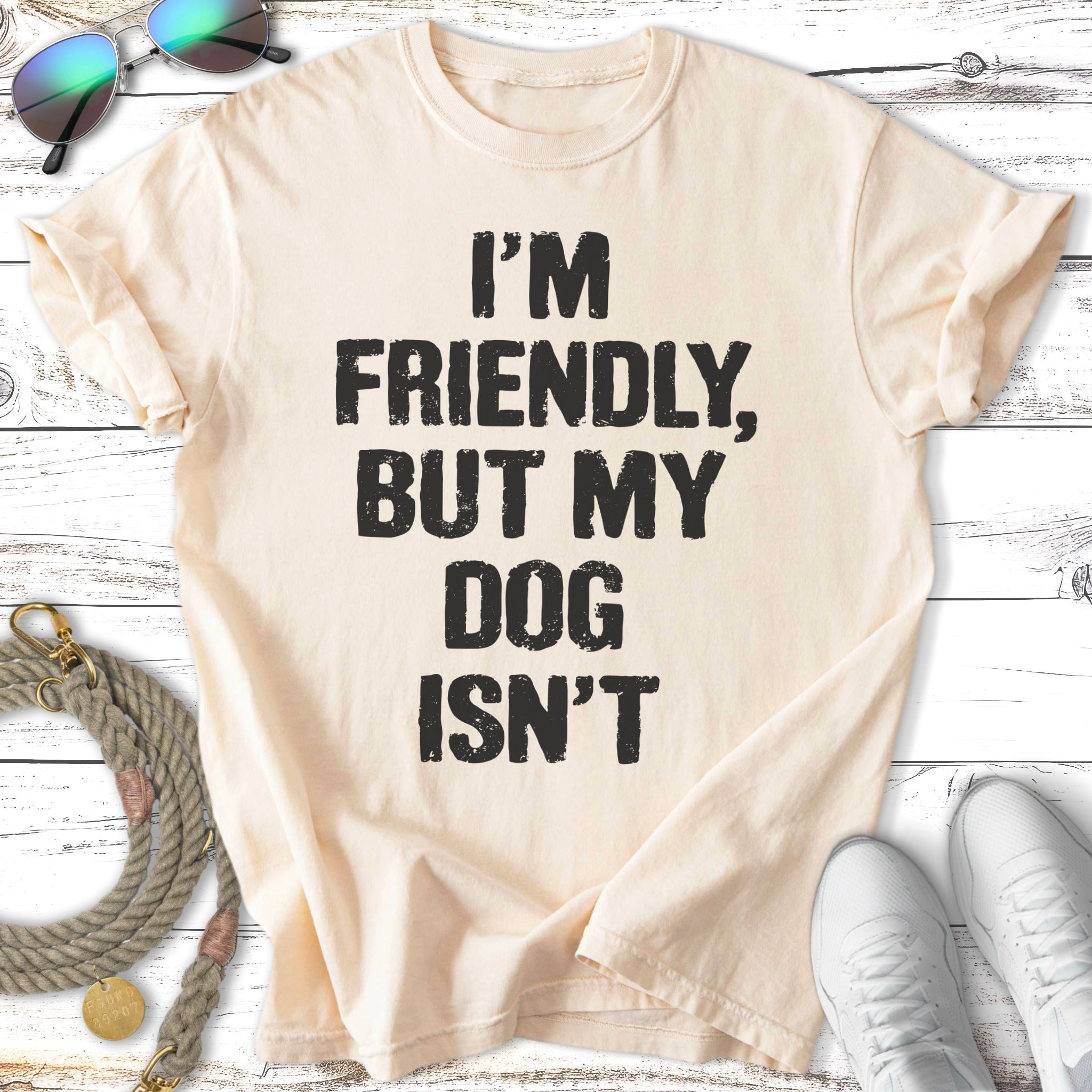 Light cream t-shirt with "I'M FRIENDLY, BUT MY DOG ISN'T" text.