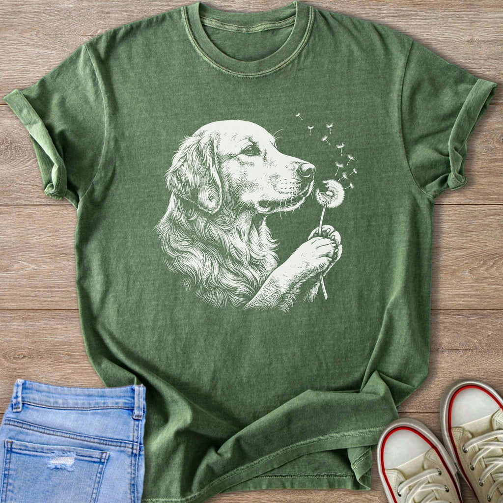 Green t-shirt with white line drawing of golden retriever blowing dandelion seeds.