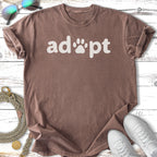 Brown t-shirt with "adopt" and paw print graphic.