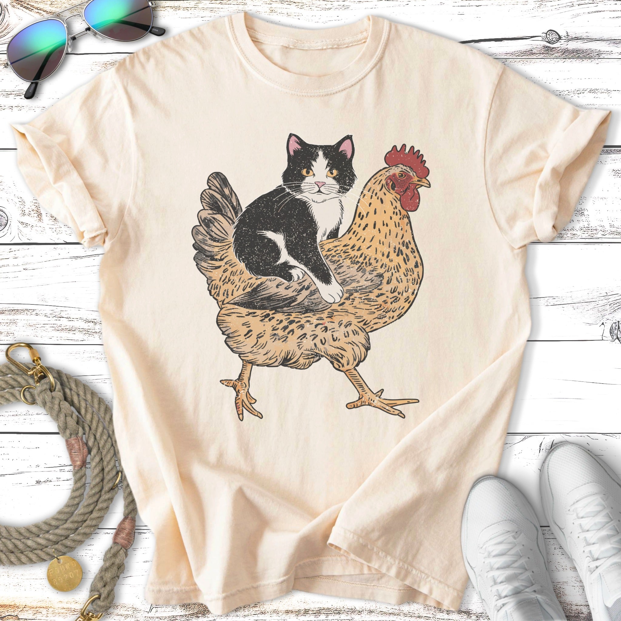 Black and white cat sitting on a stylized rooster illustration.