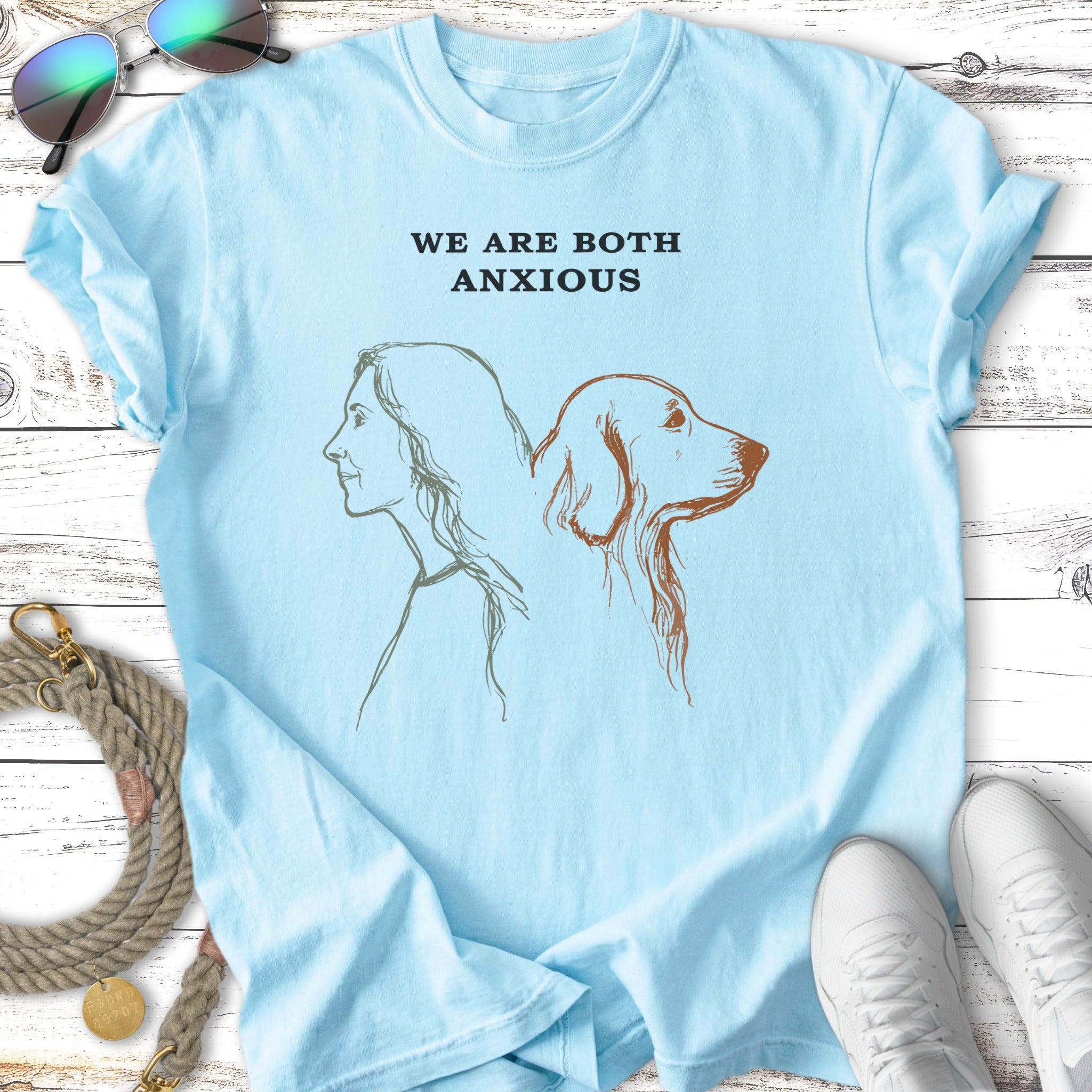 Light blue t-shirt with line drawing of a woman and dog profile, "WE ARE BOTH ANXIOUS" text.