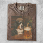 Bernese Mountain Dog wearing sunglasses and a hat, sitting by a beer.