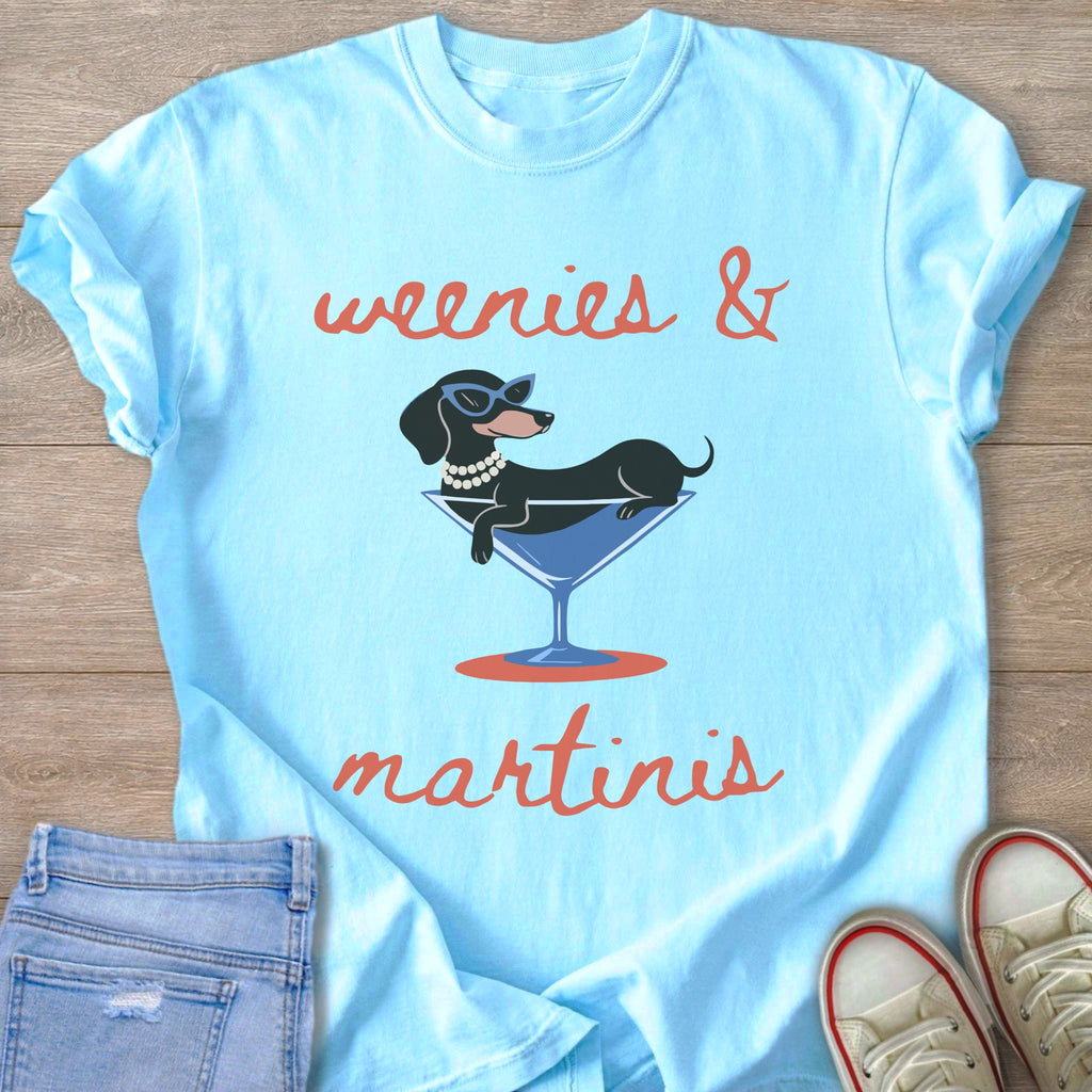 Light blue t-shirt with text "weenies & martinis" and a dachshund in a martini glass.