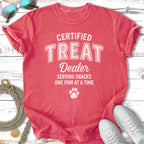 Coral t-shirt with "Certified Treat Dealer" text and paw print.