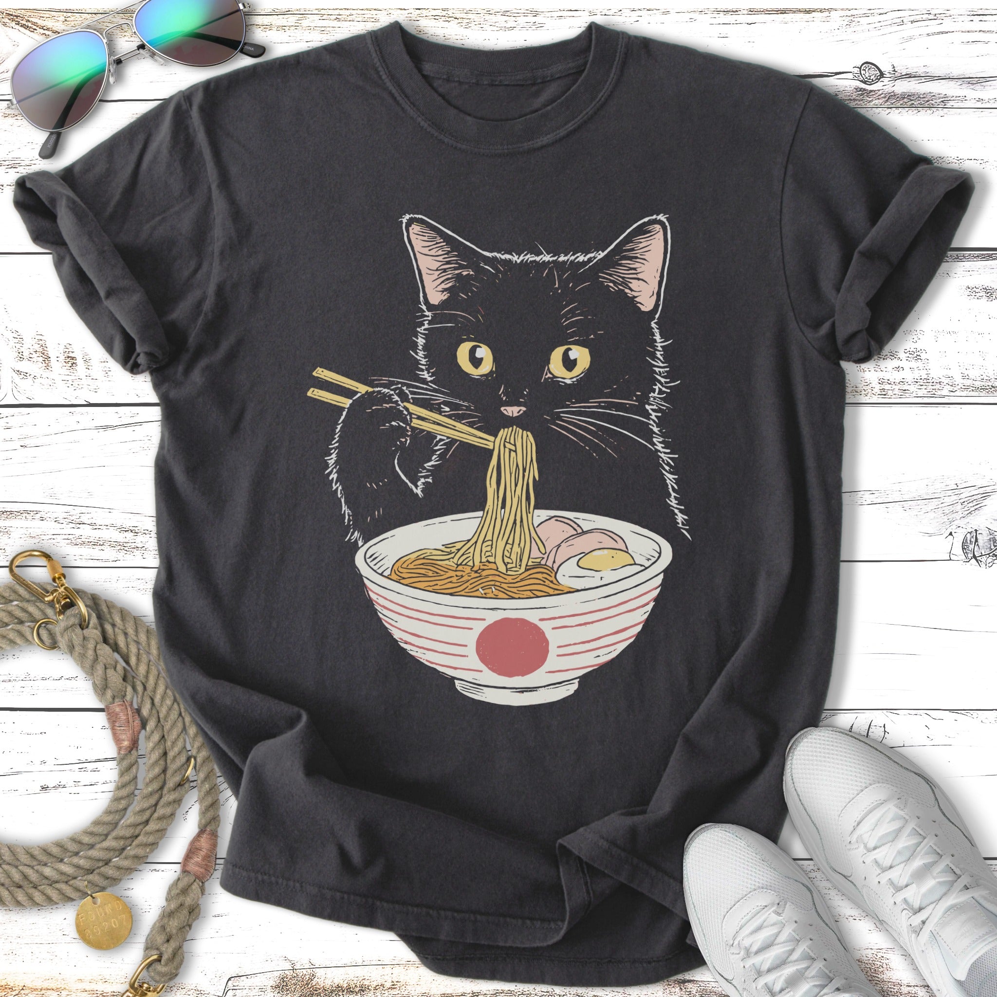 Black cat eating ramen noodles from a bowl with chopsticks.