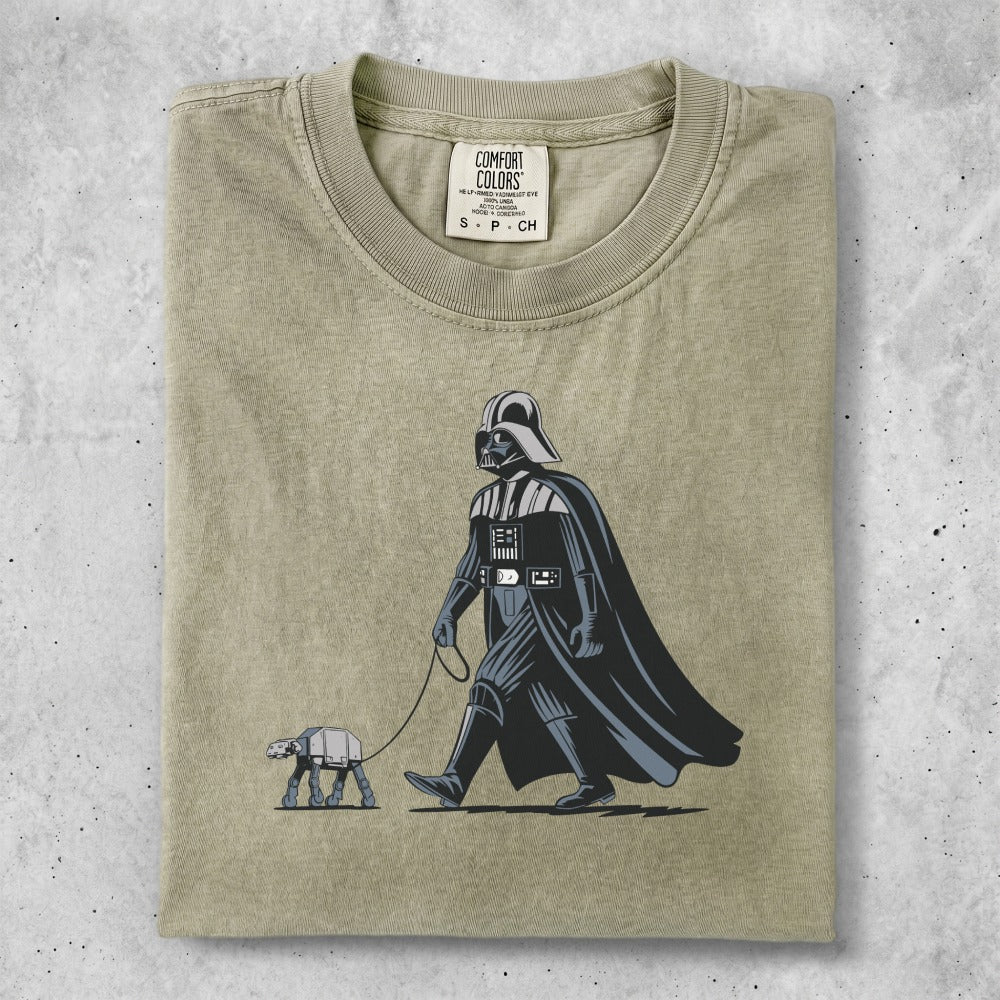 Darth Vader walks an AT-AT on a leash in a graphic tee.