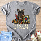 French bulldog knight with sewing tools and a small quilt, "We Quilt At Dawn" text.