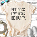 Cream t-shirt with black text "PET DOGS. LOVE JESUS. BE HAPPY."