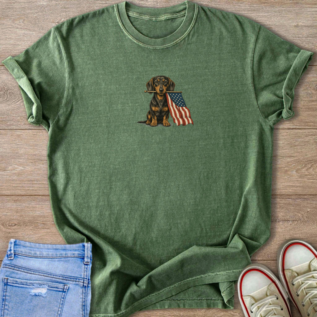 Green t-shirt with dachshund holding American flag graphic on chest.