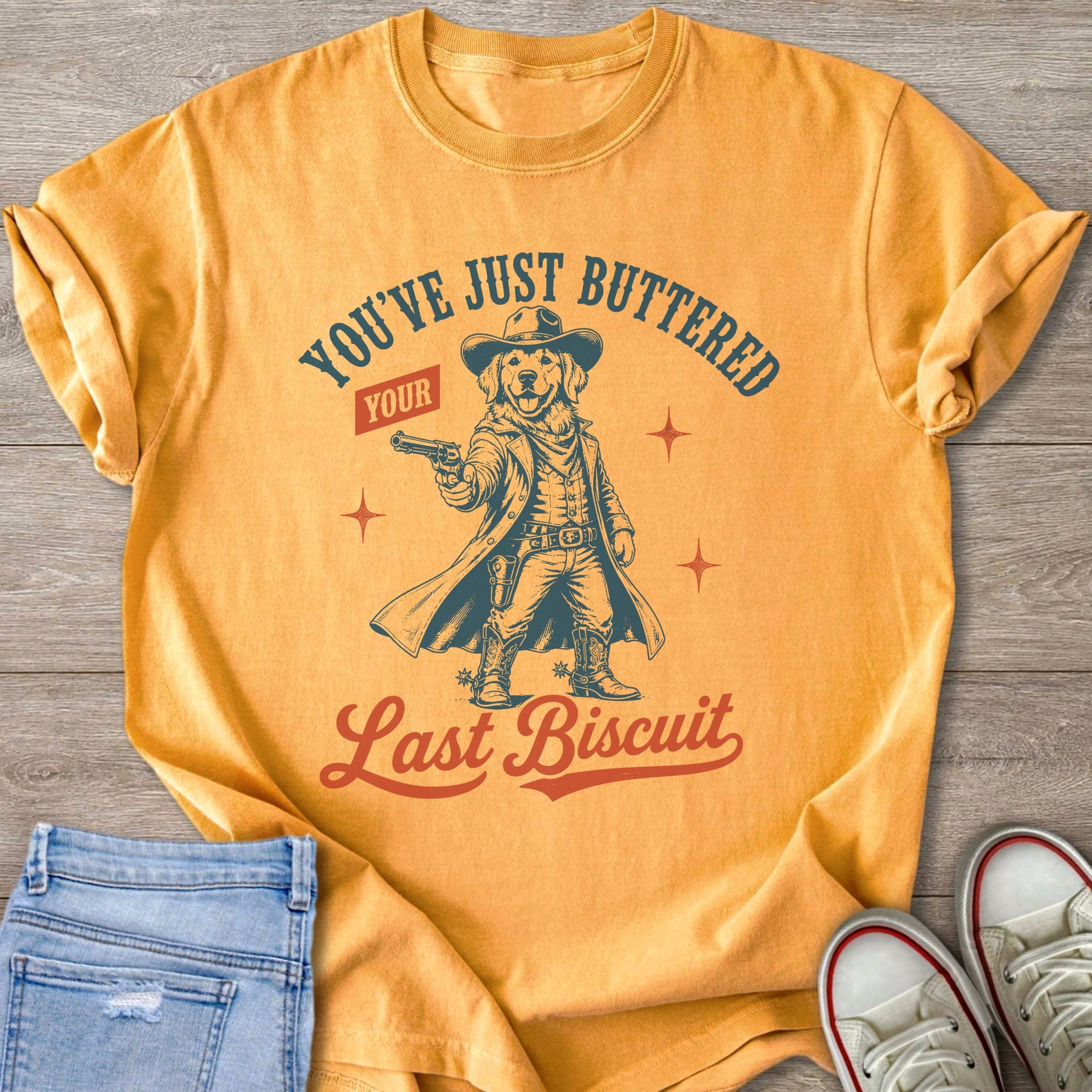 Golden retriever in cowboy attire holding a gun, with "You've Just Buttered Your Last Biscuit" text.