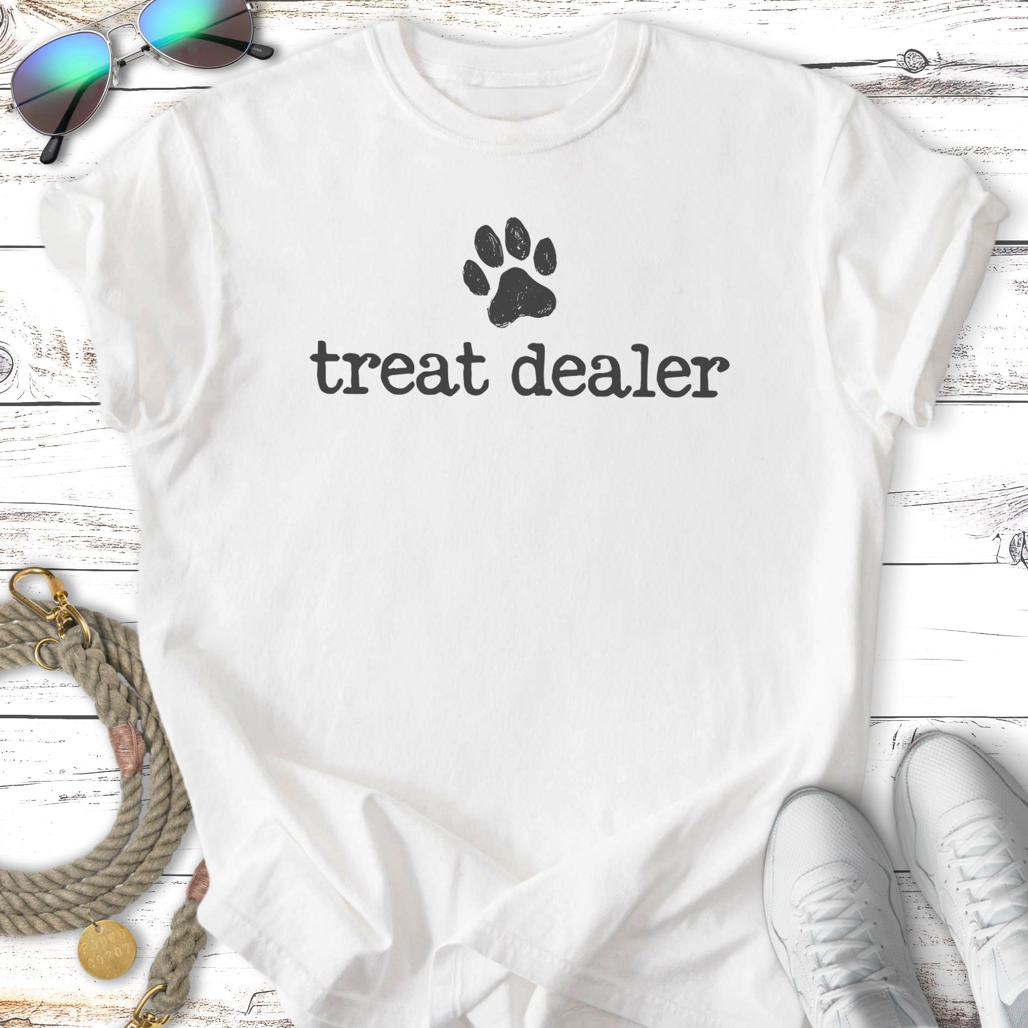 White t-shirt with "treat dealer" and a paw print.