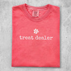 Coral t-shirt with "treat dealer" and a paw print graphic.